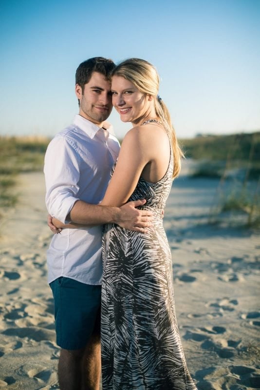 engaged couple hugs on tybee island beach