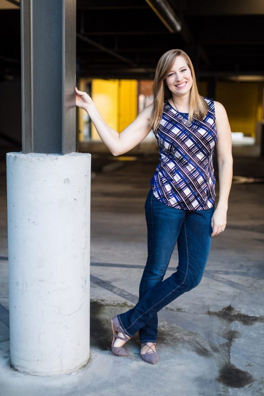 girl leans from pole in atlanta parking garage