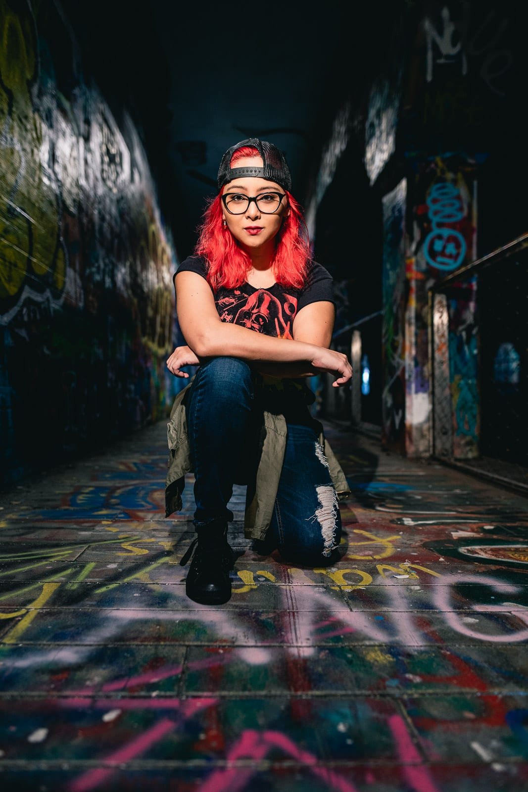punk girl kneels on graffiti walkway of krog street tunnel atlanta