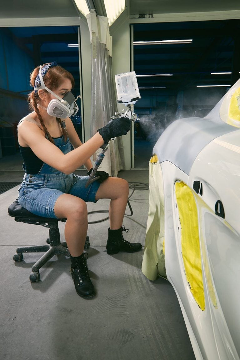 female worker paints car at atlanta repair shop