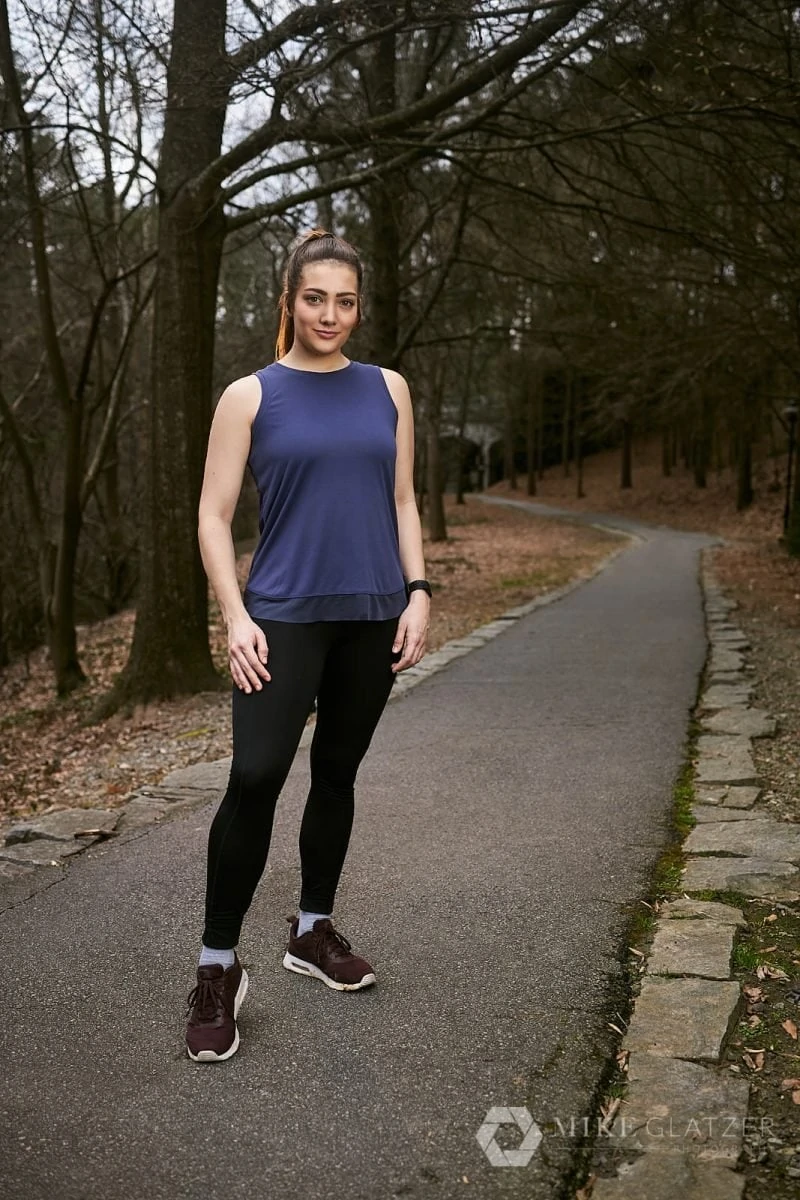 female trail runner stands on path of atlanta park