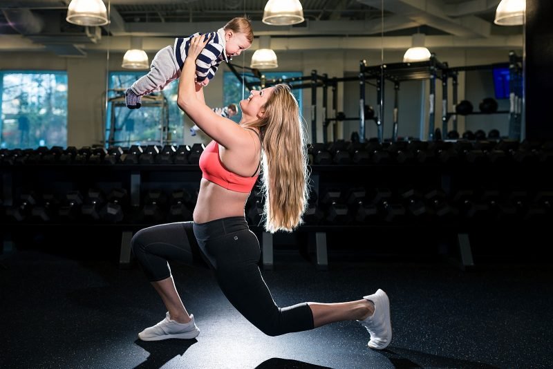 workout mom lifts son in gym