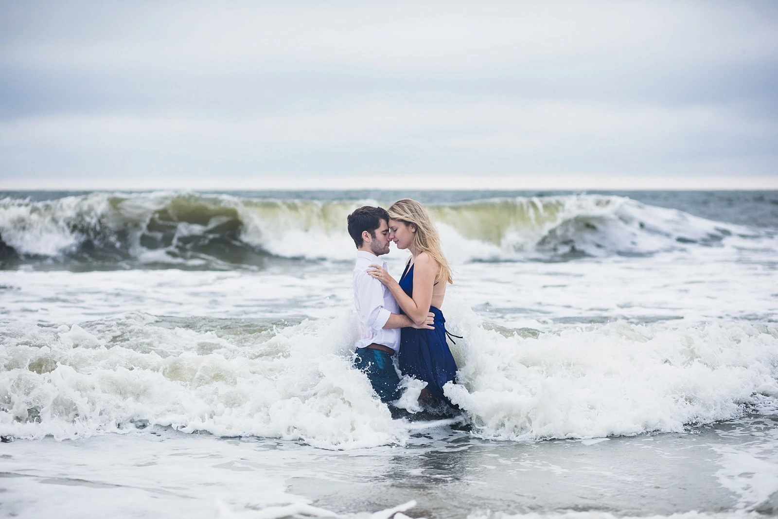 couple kisses in ocean for engagement portrait at Tybee Island beach