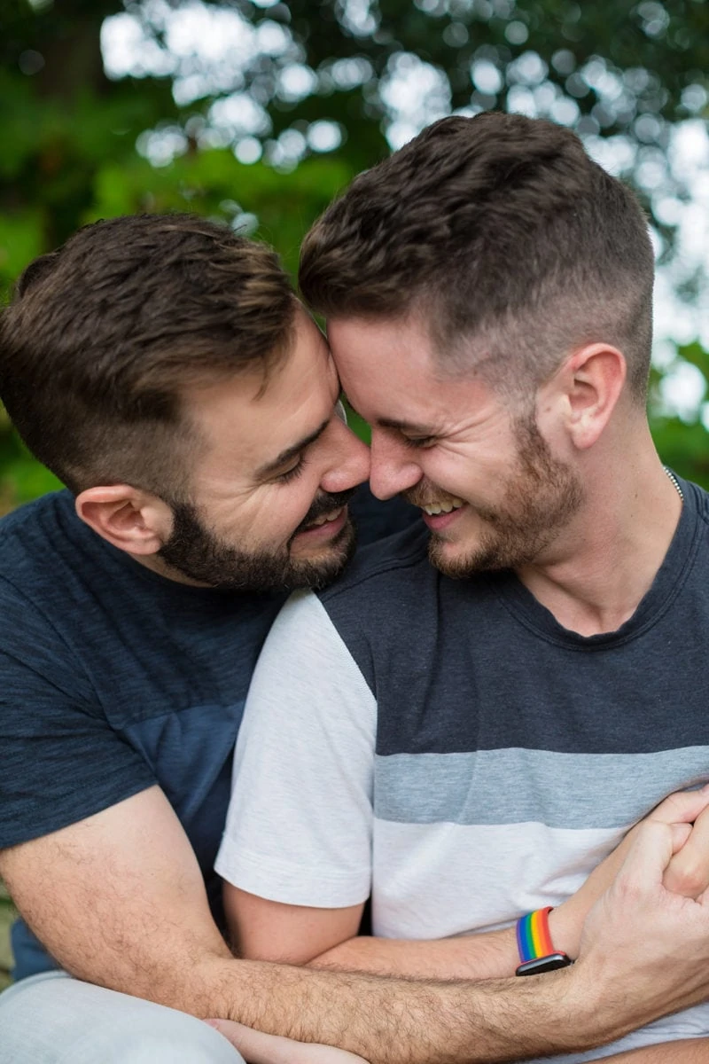 gay couple hugs for engagement portrait in Piedmont Park