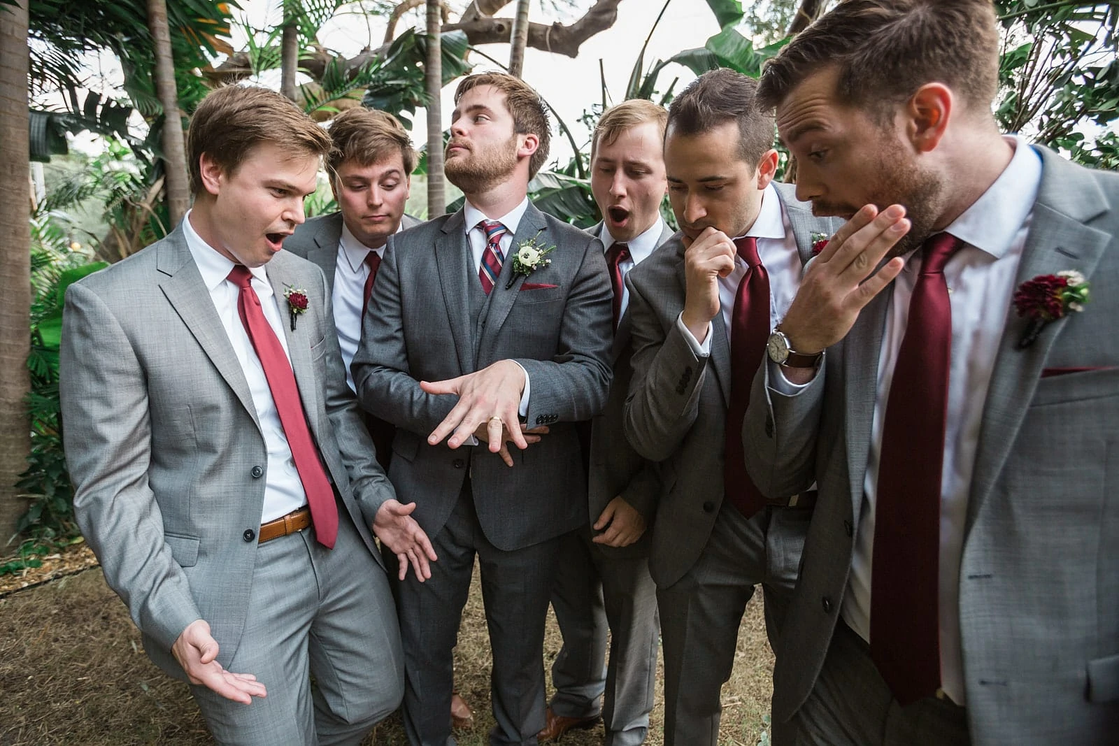 groom shows off wedding ring to groomsmen