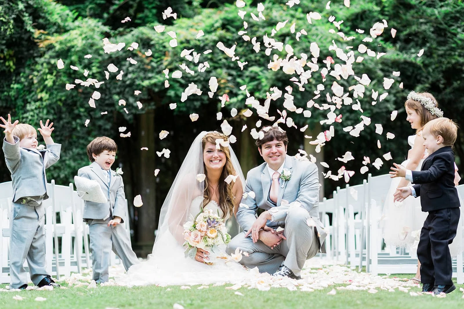 kids throw flowers over bride and groom Cator Wooldford Gardens