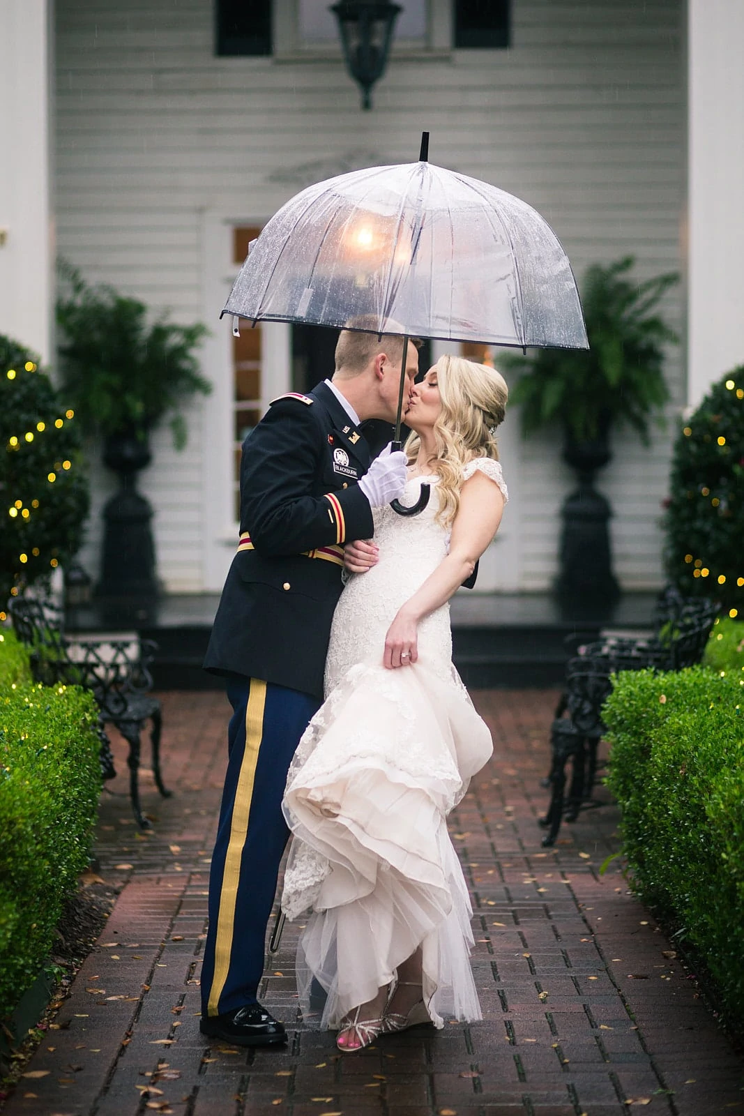 bride and groom under umbrella kiss in the rain at Roswell Founders Hall